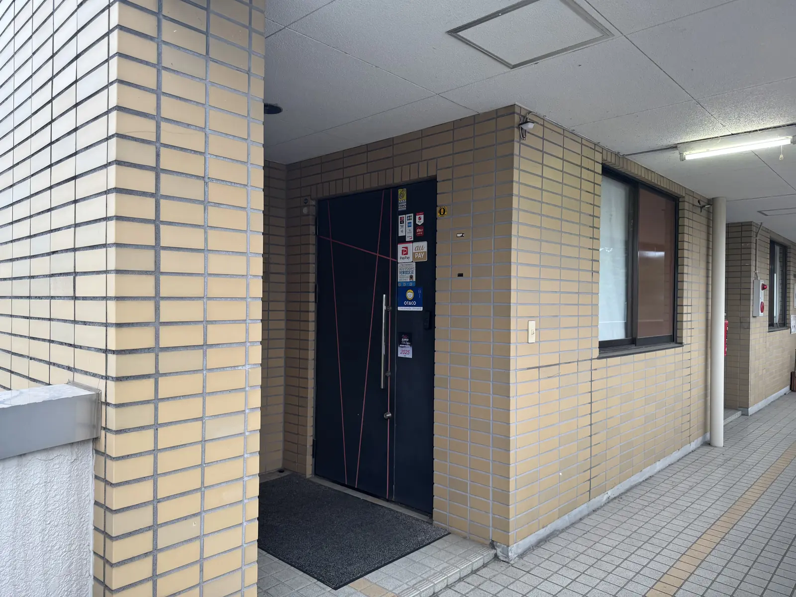 イエロートータスビル3階の通路。突き当たりに黒い扉がある