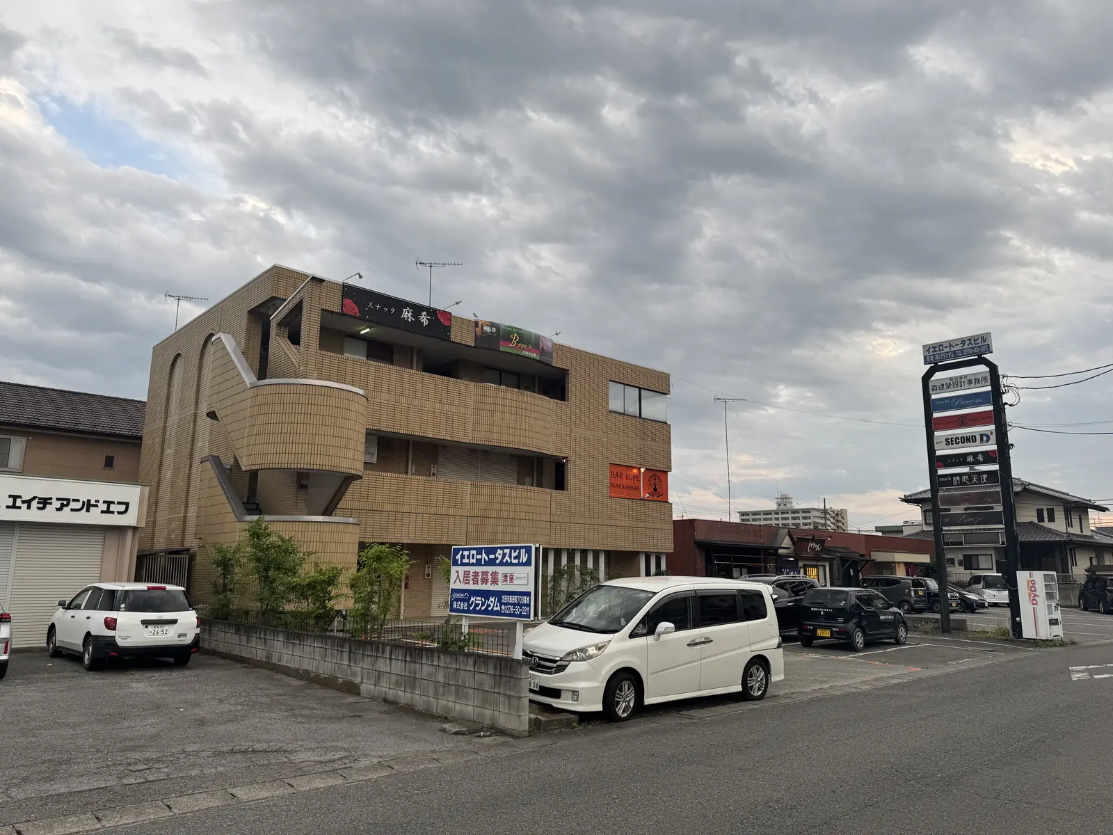 道路沿いに立つイエロートータスビルの縦看板と建物全体